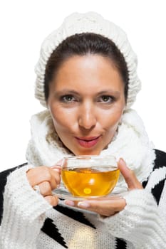 Young brunette woman with white wool lyane drinks a cup of tea to warm up isolated on white background