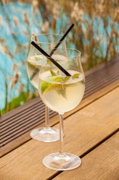 Fresh Hugo with mint lime and sparkling wine in a wine-weinin in summer by the water