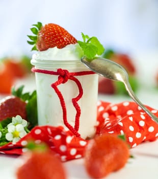 Fresh yoghurt with strawberries in a glass insulated on a white background