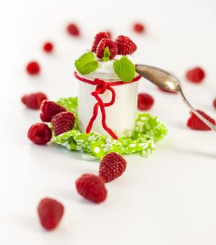 Fresh yoghurt with raspberries in a glass insulated on a white background