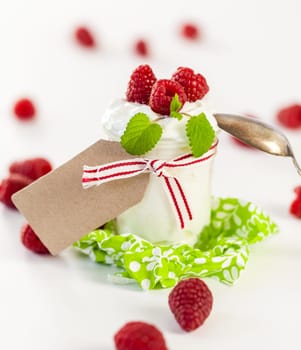 Fresh yoghurt with raspberries in a glass insulated on a white background