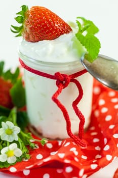 Fresh yoghurt with strawberries in a glass insulated on a white background