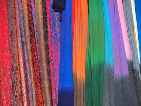 Pile of gentle folded shawls (scarfs) hanging at the market