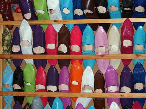 Colorful moroccan babouche shoe slippers in a shelf.