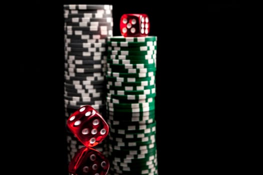 Dice and chips isolated on black background with reflexion