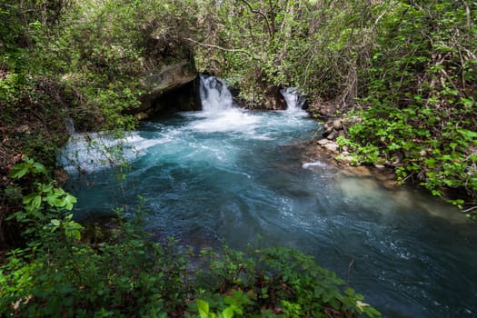 Blue water in waterfall pool in a middle of the forest