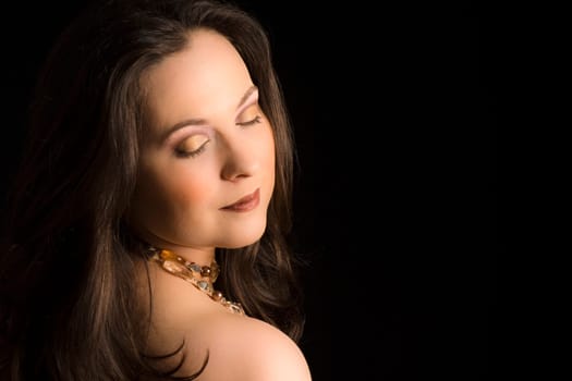Beauty portrait about a woman with make-up on black background.