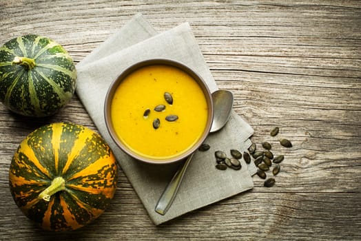 Bowl of fresh Pumpkin soup on wooden table