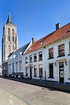 Street with traditional houses and the old church tower in Gorinchem in the Netherlands
