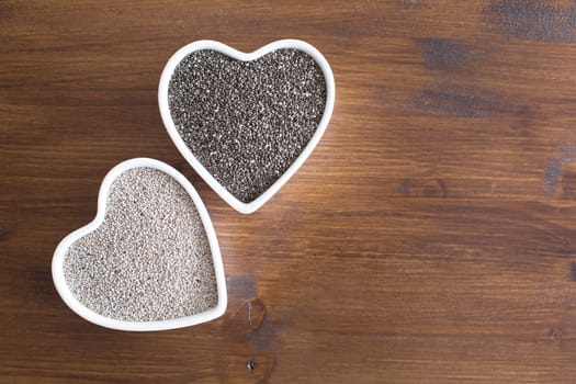 White and black chia seeds in heart shaped containers iwth room for copy