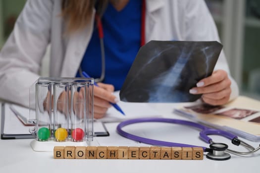 A healthcare professional is carefully examining an Xray to determine a diagnosis for bronchiectasis