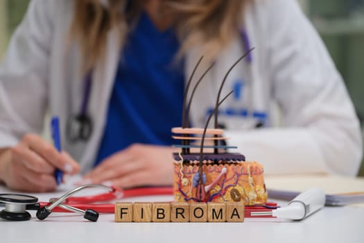 The image depicts a fibroma alongside various medical tools and a healthcare professional taking important notes
