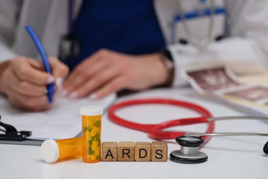 A medical professional documents key ARDS info with a stethoscope and nearby meds for effective patient care