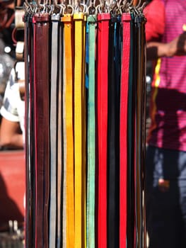A collection of unbranded belts on a market stand in Marrakech