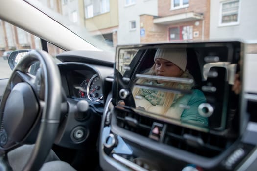 In a modern car interior, a driver carefully watches the navigation screen for directions and guidance