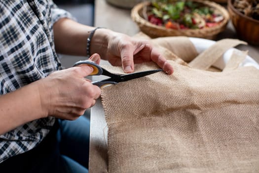 This is a closeup view showcasing hands expertly cutting burlap fabric, perfect for crafting and DIY projects