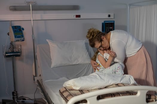 In a hospital setting, a profoundly touching moment unfolds as a mother lovingly embraces her child