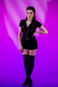 A selfassured model showcases her style in an eyecatching black outfit against a vibrant and striking purple backdrop