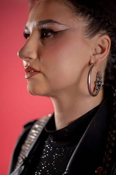 This contemporary profile shot beautifully showcases striking makeup along with fashionable clothing and accessories