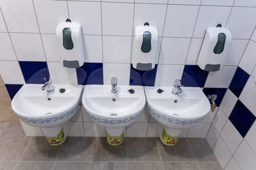 This stylish and functional bathroom setup showcases beautifully designed sinks along with handy soap dispensers