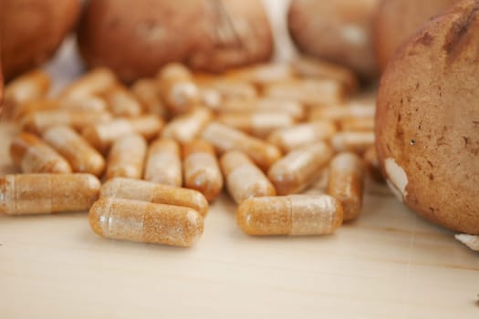 Close view of herbal capsules scattered near freshly baked bread.