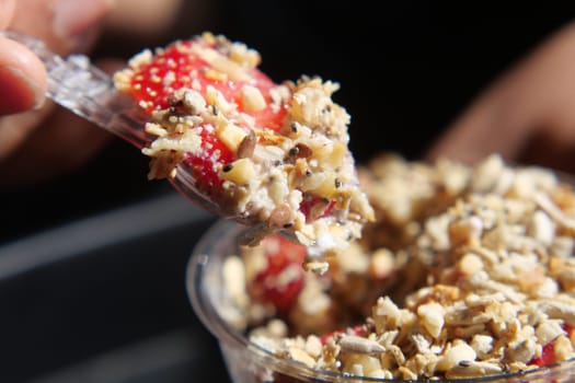 Enjoying a healthy mix of strawberries and granola on a bright morning.