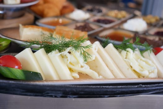 A colorful cheese platter showcases fresh vegetables and herbs, ready to enjoy.