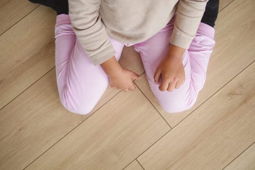 Child sitting w shape on floor .