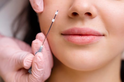 Face lifting PDO Suture operation. innovative technique of New thread lift, cosmetologist preparing to do procedure to female client, select the appropriate thread option.