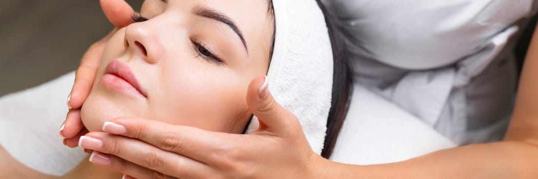 Professional anti-aging facial massage. Action. Relaxing facial treatment at Spa. Relaxing and rejuvenating facial massage for women.