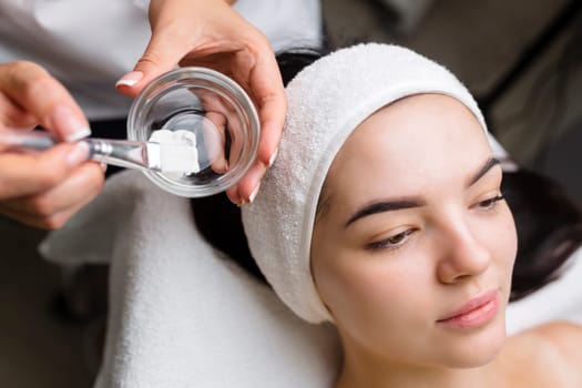 Close-up shot of a woman getting facial treatment with clay mask. Cosmetology and spa. High quality 4k footage