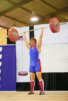 A weight lifter lifting weights during a competition