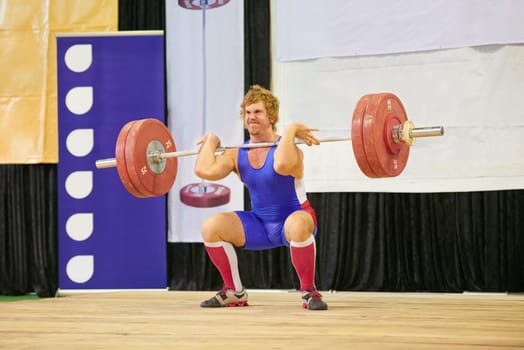 A weight lifter lifting weights during a competition