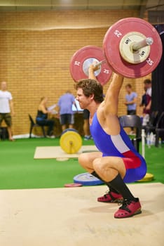 A weight lifter lifting weights during a competition