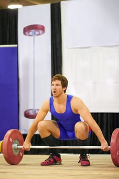 A weight lifter lifting weights during a competition