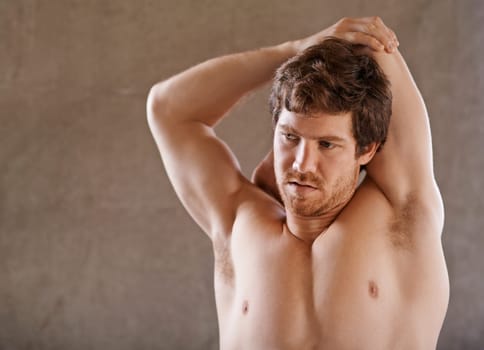 Strong young man warming up his arm muscles in preparation for a gym workout