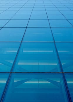 Abstract closeup of the glass-clad facade of a modern building covered in reflective plate glass