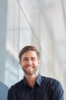 Portrait of a handsome executive looking positively at the camera in a modern setting
