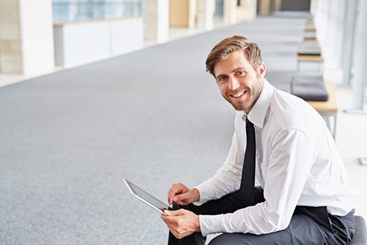 Portrait of a corporate executive smiling while using a digital tablet