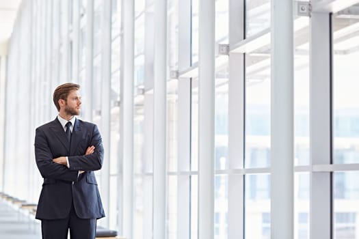 Corporate executive in a modern architectural setting looking confidently out of high rise windows