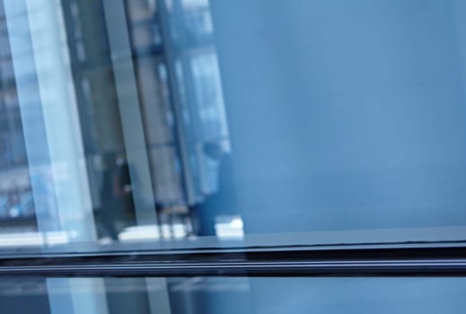 Blue tone images of real businesspeople in motion through glass in a busy conference centre