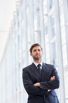 Low angle shot of a corporate executive in a modern architectural setting looking ahead confidently