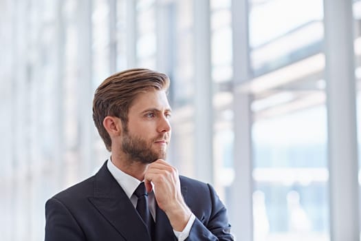 Closeup of a corporate executive looking thoughtfully and confidently out of high rise windows