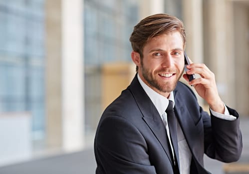 Portrait of a corporate executive smiling while talking on his phone
