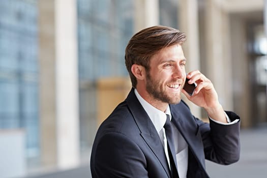 Corporate executive smiling while talking his phone and looking away