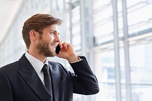 Closeup of a corporate executive looking away confidently while talking on his mobile phone