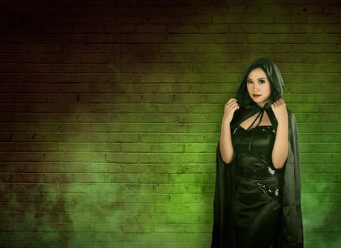 Asian witch woman in empty room with green fog, she wearing black costume