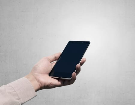 Hand holding cellphone with blank screen on grunge background. You can put your design on the cellphone