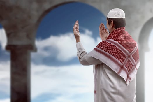 Back view of young muslim man praying
