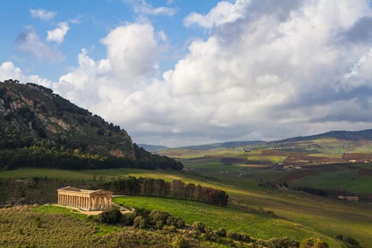 Dramatic landscape and ancient greek doric temple in Segesta archaeological area, Sicily, Italy.